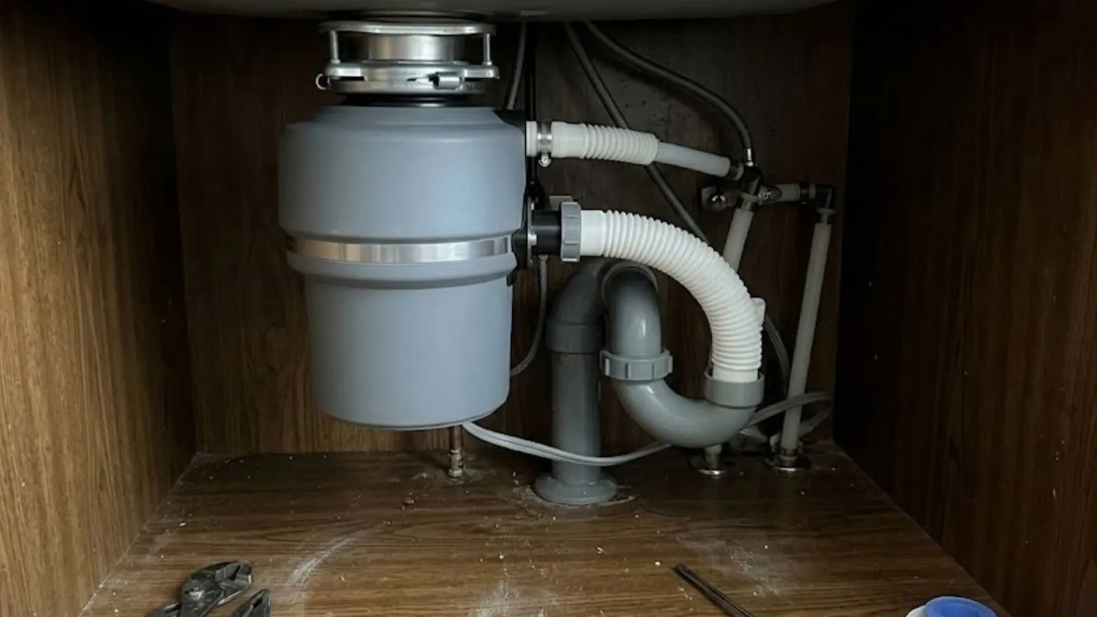 Garbage disposal and drain connections under a kitchen sink